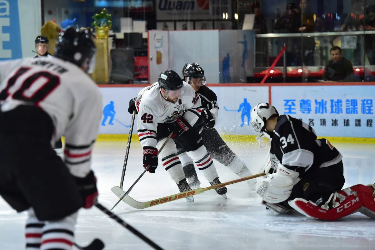 Eric McKenna (42) of Kowloon Warriors is thwarted by Soputh China Sharks goalie Emmerson Keung (34) and Craig Rossel (13) while Greg Smyth (10) is in perfect position to receive a pass, during the first playoff match between Sharks and Warriors at Mega Ice on Thursday March 24, 2016. (Bill Cox/Epoch Times)