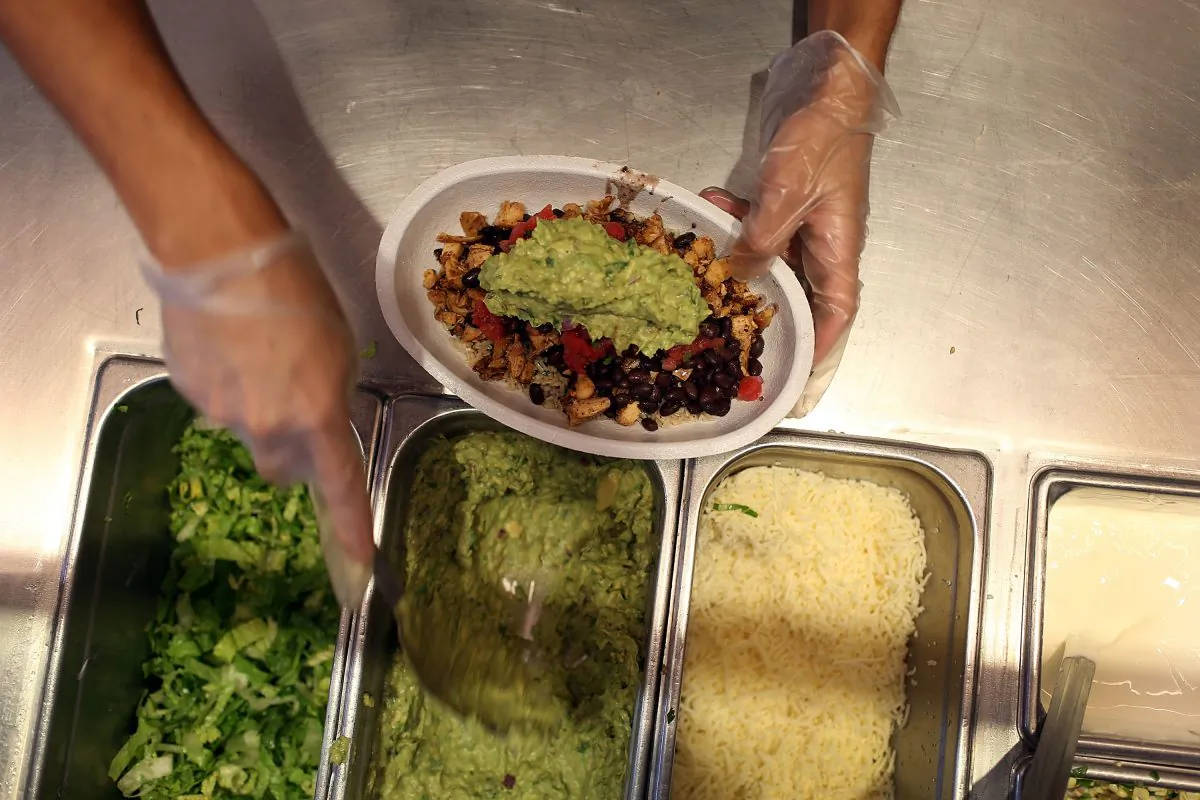 Chipotle restaurant workers fill orders for customers. (Photo by Joe Raedle/Getty Images)