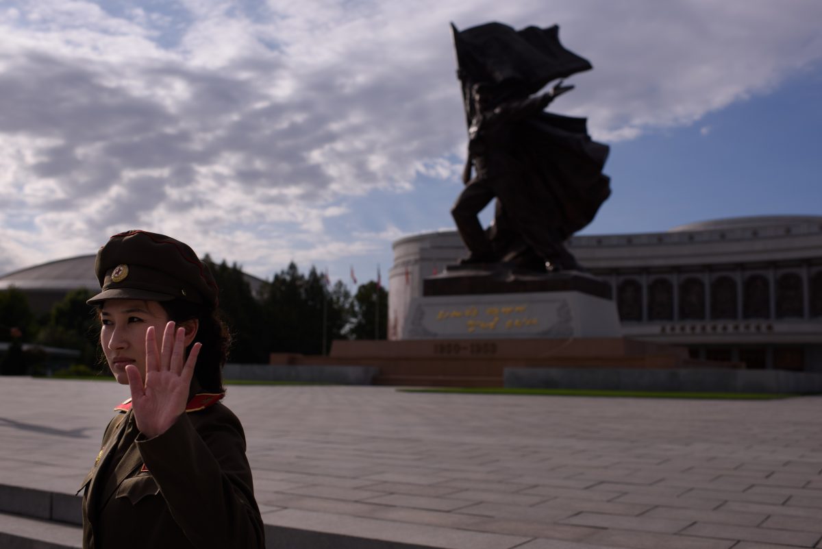 A uniformed tour guide gestures to tourists outside the War Museum in Pyongyang on October 9, 2015. North Korea is gearing up for a lavish celebration marking the 70th anniversary of its ruling Workers' Party on October 10.     AFP PHOTO / Ed Jones        (Photo credit should read ED JONES/AFP/Getty Images)