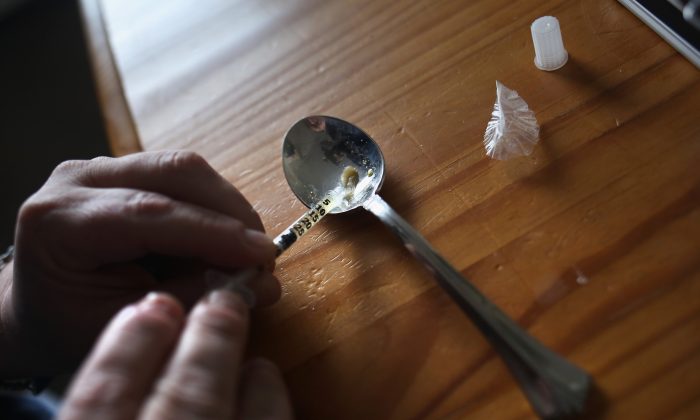 A heroin user prepares to inject himself in New London, Conn., on March 23, 2016. (John Moore/Getty Images)