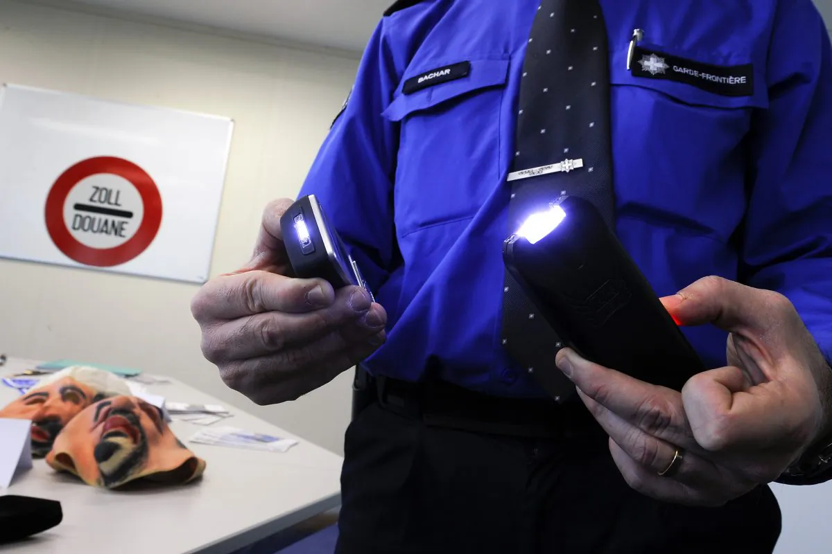 Border guards press officer Michel Bachar shows powerful tasers during a press briefing showing illegal weapons seized at a control, on February 3, 2011 in Geneva. (FABRICE COFFRINI/AFP/Getty Images)
