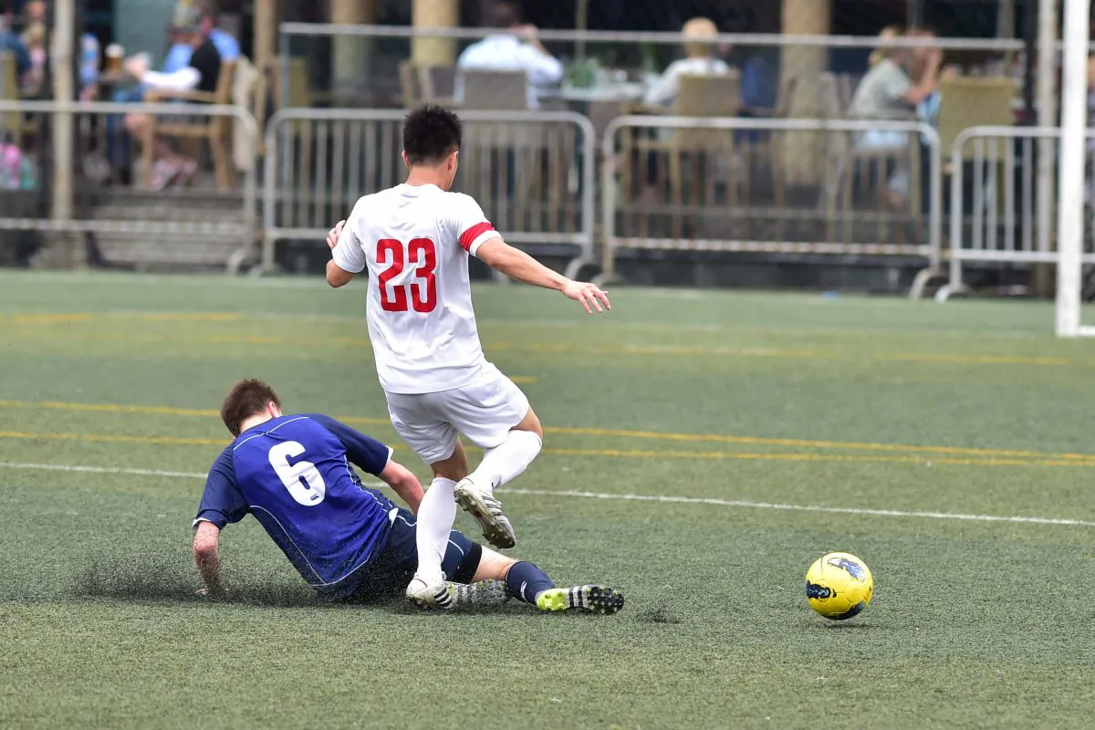Colts defender makes a timely interception as HKU70 attacker heads for goal. in their Yau Yee League division 1 match at Sports Road on Sunday April 3. (Bill Cox/Epoch Times