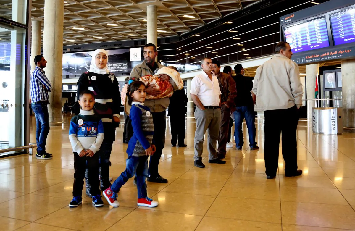 Syrian refugee Ahmad al-Abboud, center, waits with his family at the International Airport of Amman, Jordan, on April 6, 2016. (AP Photo/Raad Adayleh)