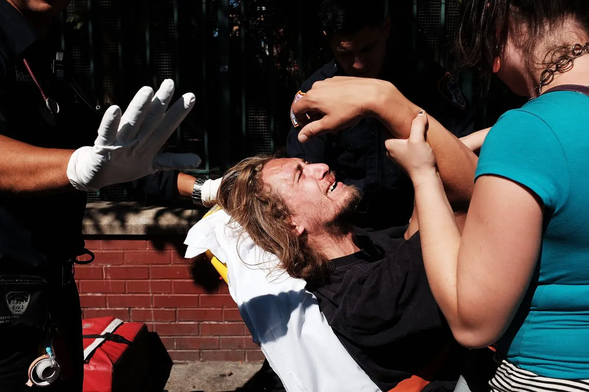 A man is consoled as paramedics take him to the hospital for what is thought to be an overdose of K2 or "Spice," a synthetic marijuana drug, along a street in East Harlem in New York City on Aug. 28, 2015. New York, along with other cities, is experiencing a deadly epidemic of synthetic marijuana usage including varieties known as K2 which can cause extreme reactions in some users. According to New York's health department, more than 120 people visited an emergency room in the city in just one week in April. While the state banned the ingredients used to make K2 in 2012, distributors have switched to other ingredients and names in an attempt to circumvent the law. (Spencer Platt/Getty Images)