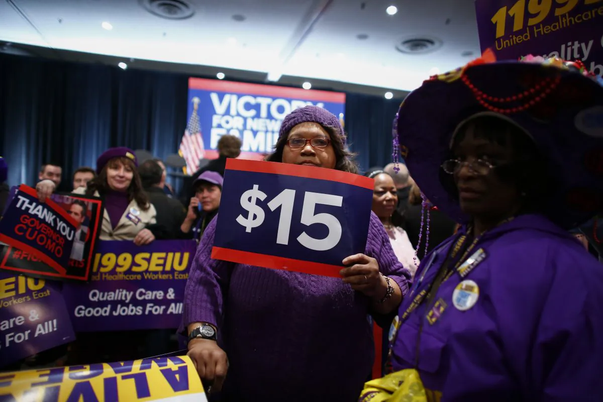 A woman holds banners before Democratic presidential candidate Hillary Clinton speaks during a event named as a "victory rally for $15 minimum wage and paid family leave" at the Javitz Center in New York on April 4, 2016. (Kena Betancur/AFP/Getty Images)