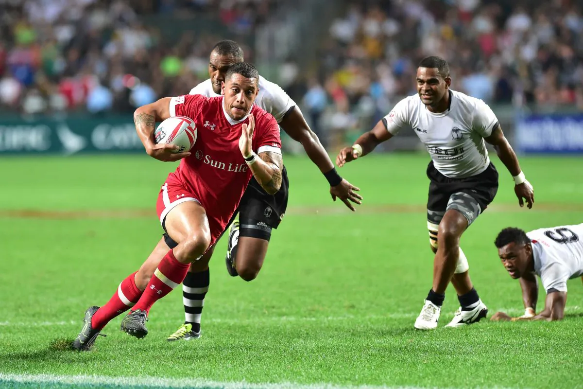 Mike Fuailefau of Canada strides away from Fiji players in their 1st round match of the Pool games at the Cathay Pacific/HSBC Hong Kong Sevens on Friday April 8, 2016. (Bill Cox/Epoch Times)
