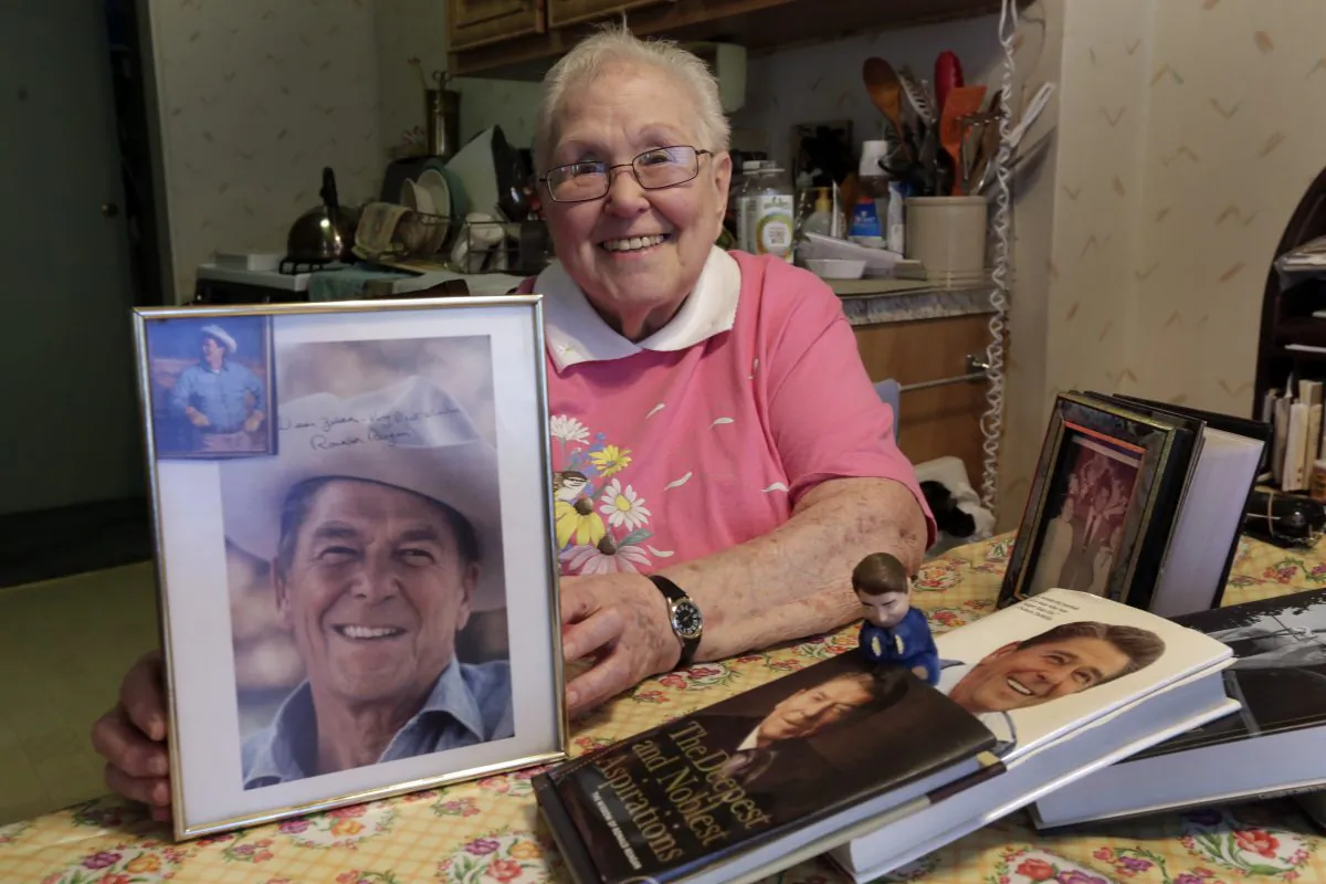In this Friday, April 1, 2016 photo, former Ronald Reagan International Fan Club president Zelda Multz, 89, poses for photos with Reagan memorabilia in her apartment in the Brooklyn borough of New York. Reagan had an army of star-struck movie fans who wrote him letters - and who to their surprise often got a personal reply. For one writer in particular the replies added up to well more than 100 as Multz evolved from teenage president of the Reagan fan club to a lifelong literary friend of the man who, 40 years after she first wrote to him, became the nation's 40th president. The letters are going on the auction block April 18. (AP Photo/Richard Drew)