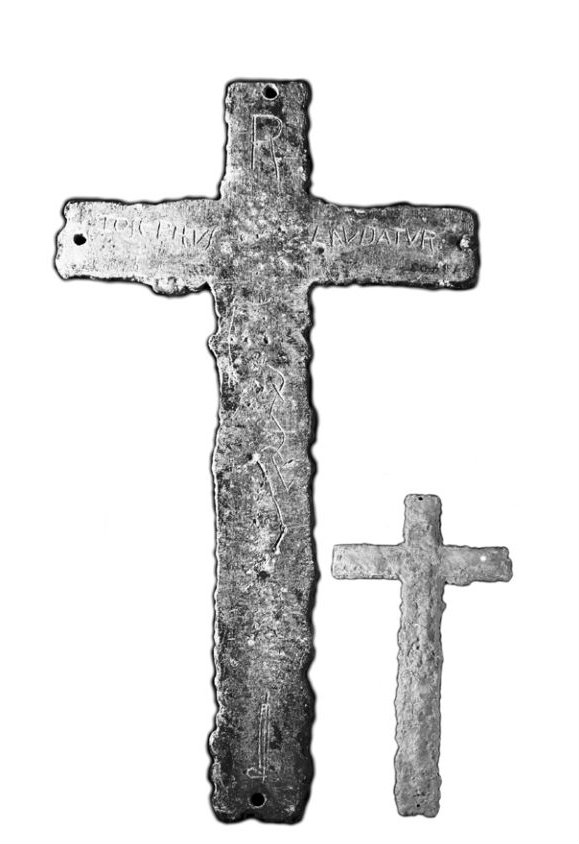 A lead cross, about 12 inches tall. The inscription reads,