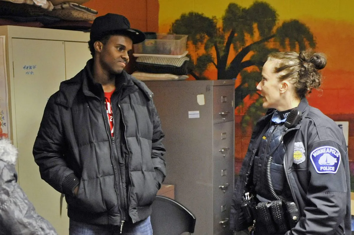 In this Jan. 14, 2011 photo, Abdirizak Mohamed Warsame visits with Minneapolis police Officer Jeanine Brudenell during an event for Somali youth at a Minneapolis community center. Warsame was arrested by federal authorities in December 2015 and recently pleaded guilty to terror charges. His arrest shocked many, because he had been surrounded by positive influences. (AP Photo/Jim Mone)