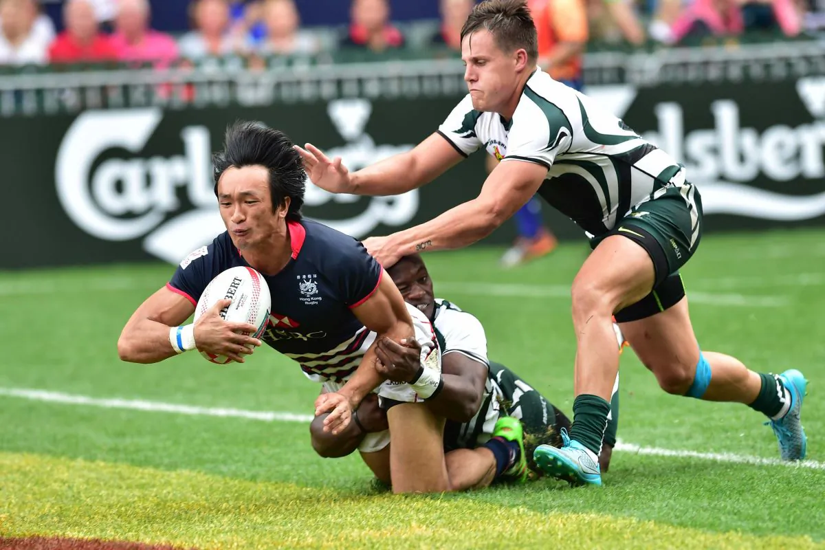 Salom Yiu of Hong Kong digs deep to secure a try against Zimbabwe in their Qualifier Pool match in the Hong Kong Sevens at Hong Kong Stadium on Saturday April 9, 2016 (Bill Cox/Epoch Times)