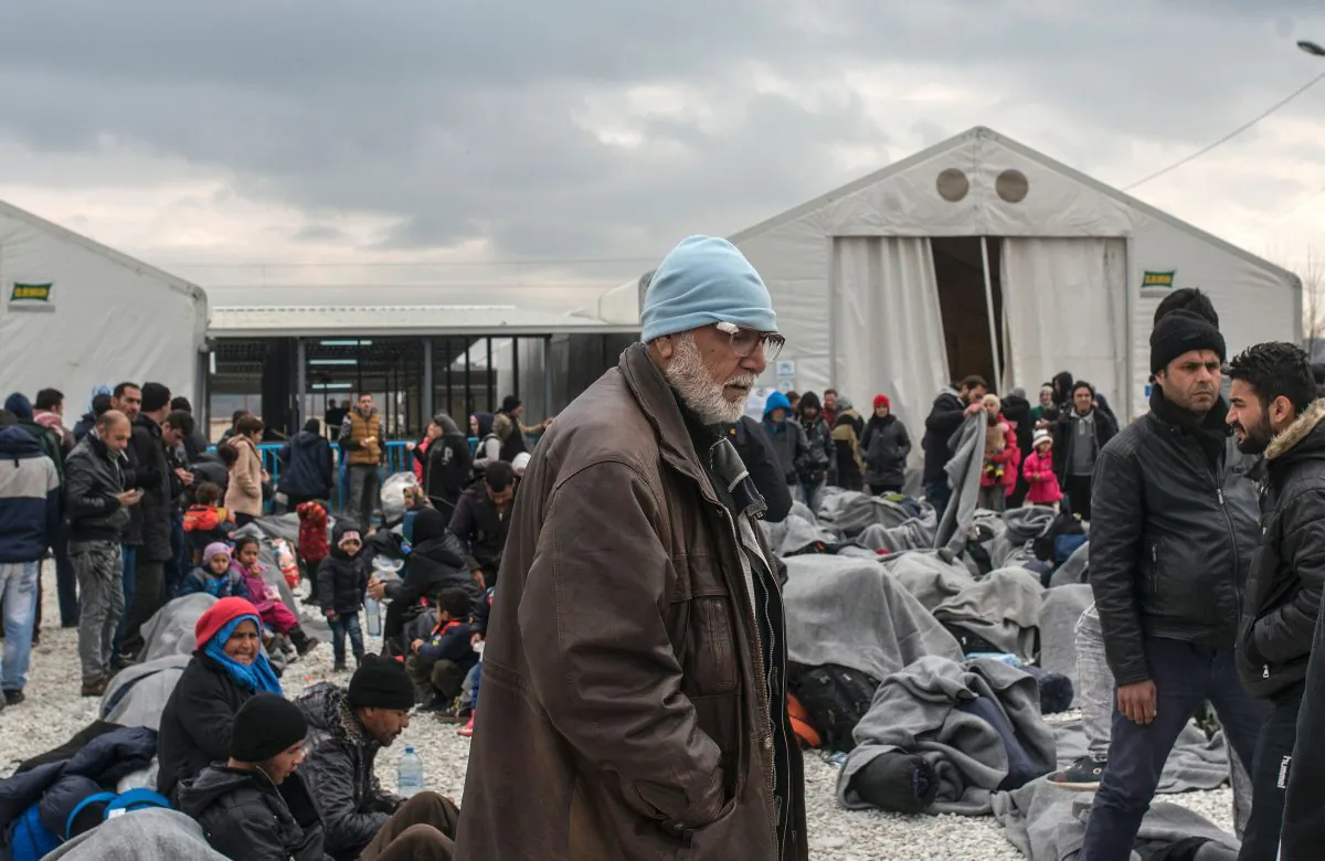 A man looks on as migrants and refugees rest in a camp as they wait for a train to Serbia near Gevgelija on the Macedonian-Greek border on Feb. 26, 2016. (Robert Atanasovski/AFP/Getty Images)