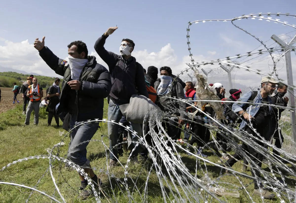 A group of migrant men call to others during protests at a fence at the northern Greek border point of Idomeni, Greece, on April 10, 2016. Thousands of migrants protested at the border and clashed with Macedonian police. (AP Photo/Amel Emric)