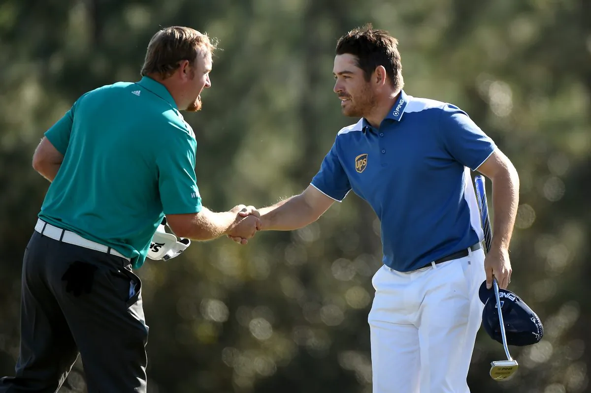 J.B. Holmes (L) and Louis Oosthuizen shake hands after finishing on the 18th green during the final round of the 2016 Masters Tournament at Augusta National Golf Club. (Harry How/Getty Images)