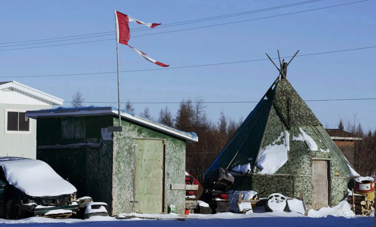 In this Nov. 29, 2011 photo, a tattered Canadian flag flies over a building in Attawapiskat, Ontario, Canada. (Adrian Wyld/The Canadian Press via AP)
