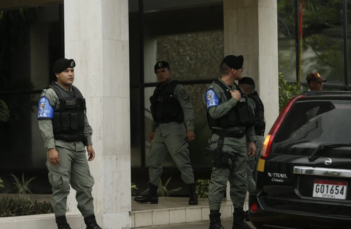 Police officers stand outside Mossack Fonseca law firm while Organized crime prosecutors raid the offices, in Panama City, Tuesday, April 12, 2016. (AP Photo/Arnulfo Franco)