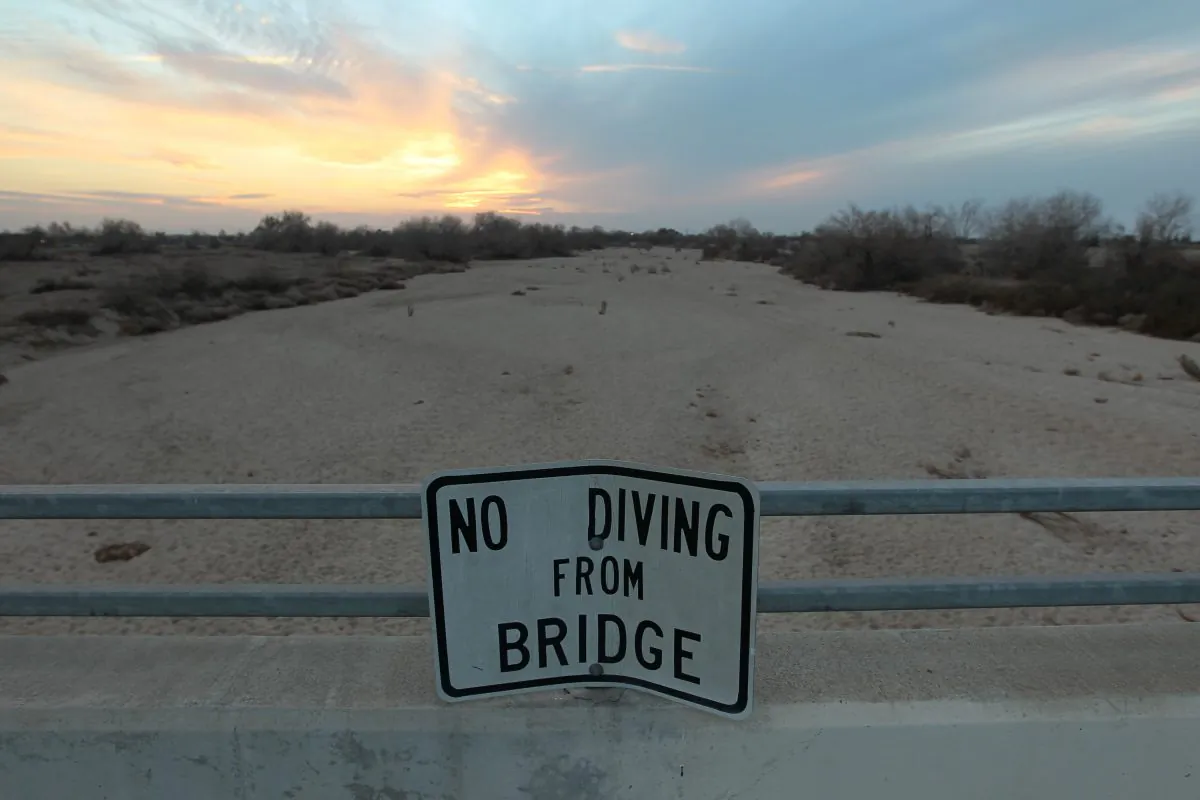 A sign from wetter times warns people not to dive from a bridge over the Kern River, which has been dried up by water diversion projects and little rain, in Bakersfield, Calif., on Feb. 4, 2014. (David McNew/Getty Images)