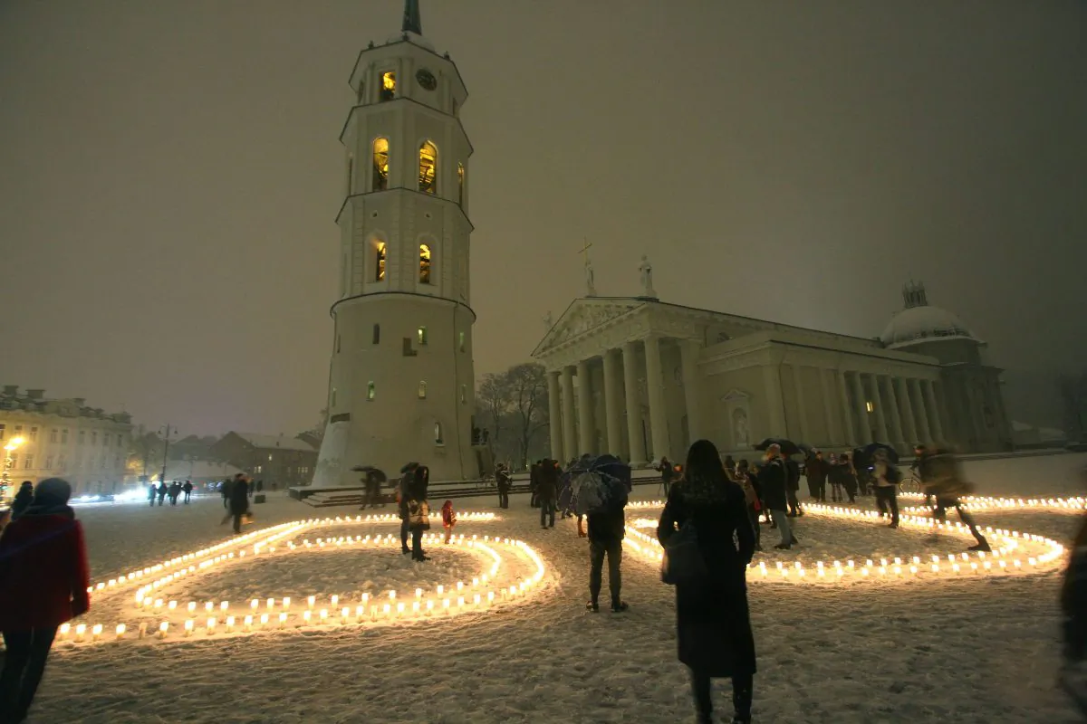 People attend a candle light vigil at the Vilnius Cathedral as it stands unlit during Earth Hour in Vilnius on March 19, 2016. Lights went off in thousands of cities and towns across the world for the annual Earth Hour campaign, aiming to call for action on climate change. (Petras Malukas/AFP/Getty Images)