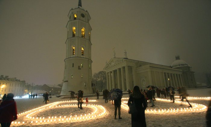 People attend a candle light vigil at the Vilnius Cathedral as it stands unlit during Earth Hour in Vilnius on March 19, 2016. Lights went off in thousands of cities and towns across the world for the annual Earth Hour campaign, aiming to call for action on climate change. (Petras Malukas/AFP/Getty Images)