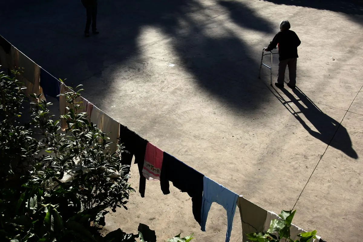 A senior citizen takes a walk in the yard of the Happy Times Nursing Home in Kunming, Yunnan Province, China, on Dec. 12, 2007. Two-thirds of the elederly residents in the nursing home suffer from senile dementia. China's population is ageing; with currently over 140 million elderly citizens, the figure is expected to grow at an annual rate of about 3.2% in the next 50 years. (China Photos/Getty Images)