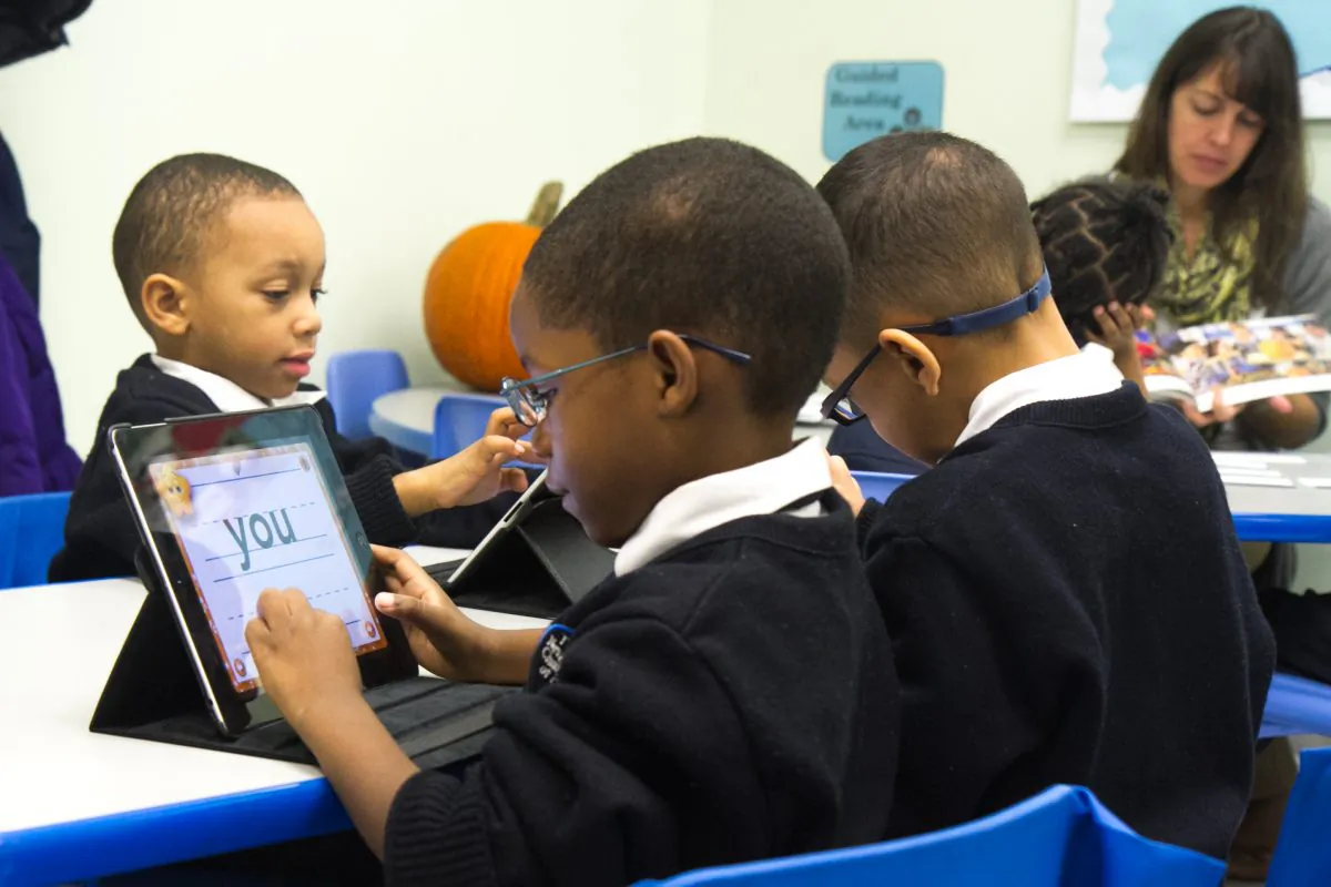 First graders at a charter school in New York use Apple iPads as one of their tools to learn to read and write in this file photo. (Benjamin Chasteen/The Epoch Times)