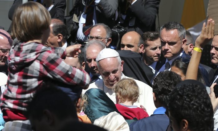 Pope Francis meets migrants at the Moria refugee camp on the Greek island of Lesbos,  Saturday April 16, 2016. Pope Francis travelled Saturday to Greece for a brief but provocative visit to meet with refugees at a detention center as the European Union implements a controversial plan to deport them back to Turkey. (AP Photo/Petros Giannakouris)
