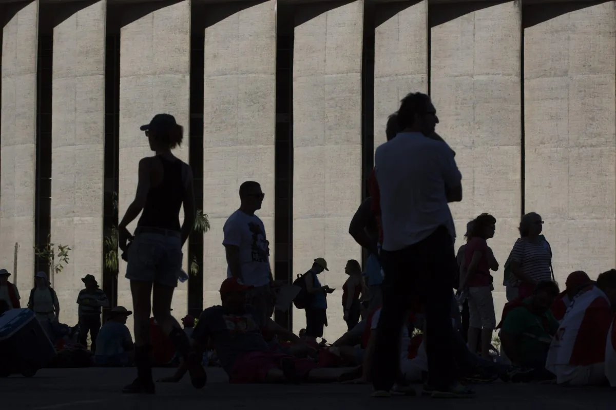 Pro-government demonstrators gather in the shade outside Congress where lawmakers are voting on whether to impeach Brazil's President Dilma Rousseff, in Brasilia, Brazil, on April 17, 2016. The vote will determine whether the impeachment proceeds to the Senate. Rousseff is accused of violating Brazil's fiscal laws to shore up public support amid a flagging economy. (AP Photo/Felipe Dana)