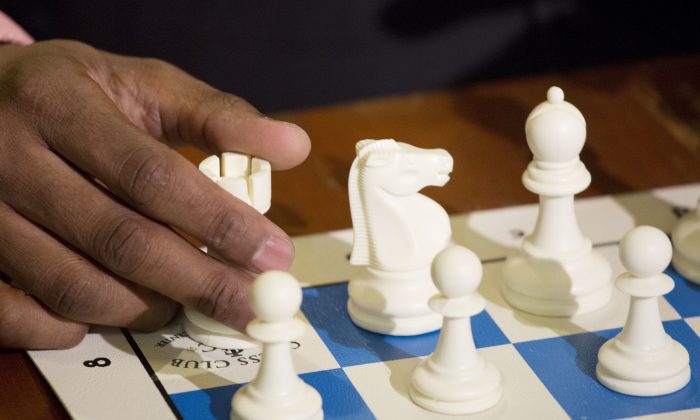 A chess player his hand on a rook piece in a 2016 file photo.  (AP Photo/Mark Lennihan)