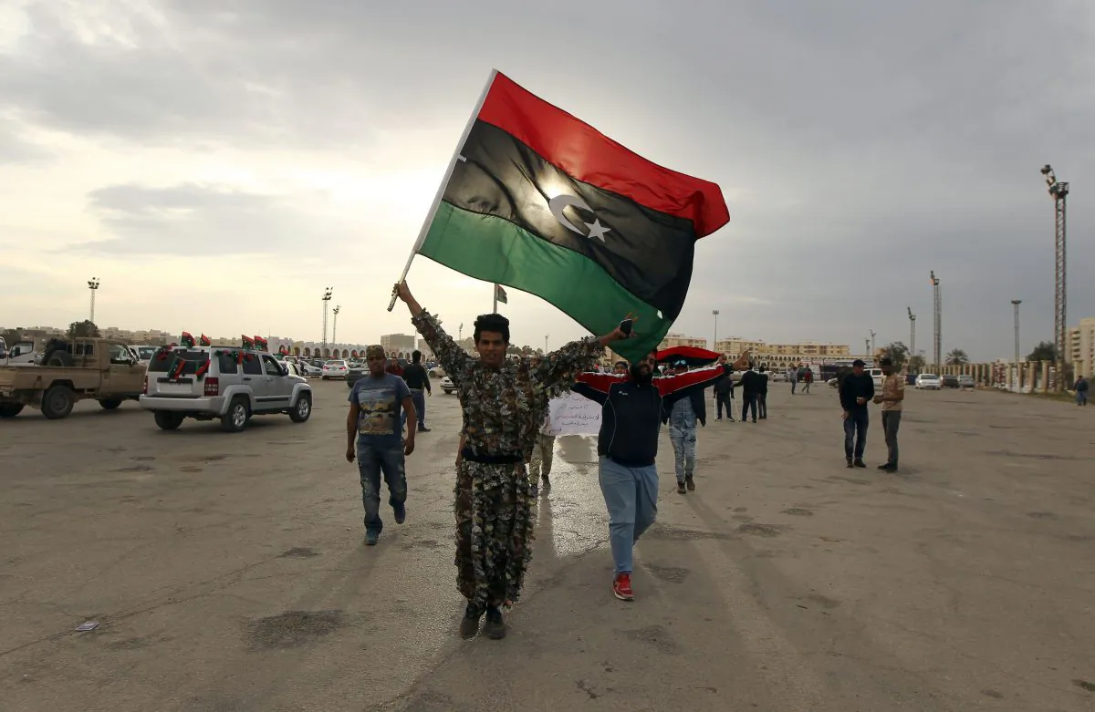 Libyans wave their national flag during a demonstration marking the fifth anniversary of the Libyan revolution, which toppled strongman Moammar Gadhafi, in the city of Benghazi, the 2011 uprising's birthplace, on Feb. 17, 2016. (Abdullah Doma/AFP/Getty Images)