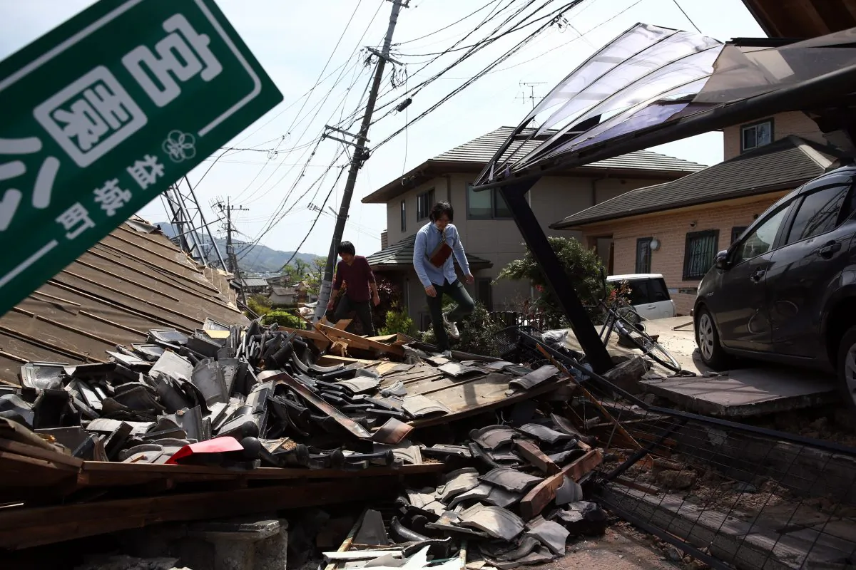 A man walks past the rubble of a collapsed house following an earthquake, on April 20, 2016 in Mashiki near Kumamoto, Japan. As of April 20, 48 people were confirmed dead after strong earthquakes rocked Kyushu Island of Japan. (Photo by Carl Court/Getty Images)