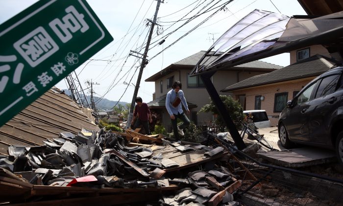 A man walks past the rubble of a collapsed house following an earthquake, on April 20, 2016 in Mashiki near Kumamoto, Japan. As of April 20, 48 people were confirmed dead after strong earthquakes rocked Kyushu Island of Japan. (Photo by Carl Court/Getty Images)