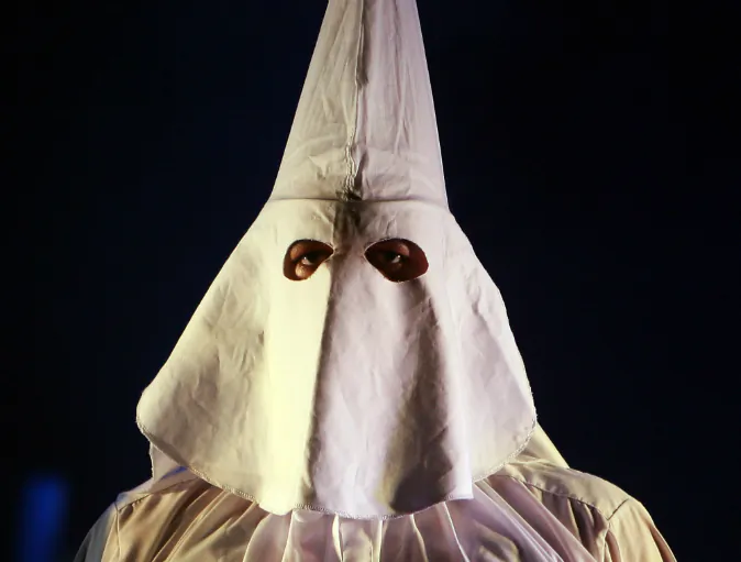 A performer in the Klu Klux Klan dance number stands on stage during the 'Jerry Springer: The Opera' photocall at the Sydney Opera House in Sydney, Australia. (Photo by Mark Kolbe/Getty Images)