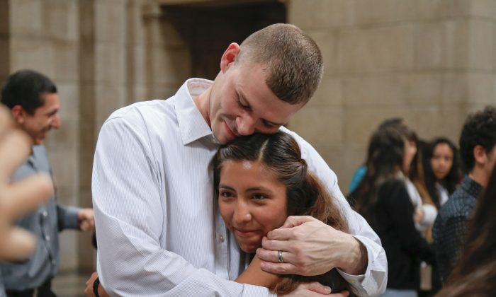 Helen Estanislao and  Antonio Perez celebrate outside the Legislative Chamber at the State Capitol in Lincoln, Neb., Wednesday, April 20, 2016, after Nebraska lawmakers overrode Gov. Pete Ricketts veto of a bill that would allow certain immigrants to get professional licenses. The bill would apply to young immigrants who entered the country illegally but received temporary legal status under a 2012 Obama administration policy. (AP Photo/Nati Harnik)