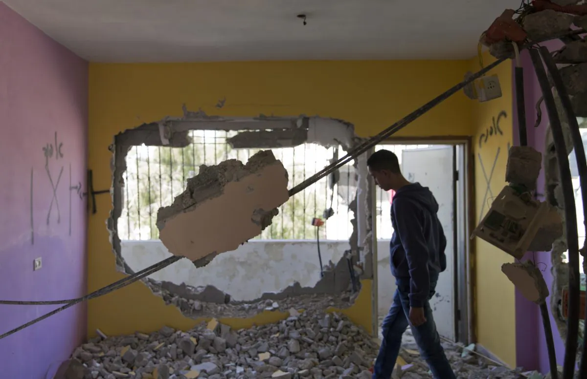 A Palestinian man inspects the damaged house of Hussein Mohammed Abu Ghosh, that was demolished by the Israeli army, in the West Bank refugee camp of Qalandia, Ramallah, on April 20, 2016. (AP Photo/Nasser Nasser)