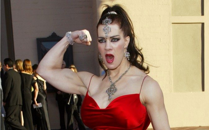In this Nov. 16, 2003 file photo, Joanie Laurer, former pro wrestler known as Chyna, flexes her bicep as she arrives at the 31st annual American Music Awards, in Los Angeles. Chyna, the WWE star who became one of the best known and most popular female professional wrestlers in history in the late 1990s, has died at age 45. Los Angeles County coroners Lt. Larry Dietz says Chyna, whose real name is Joan Marie Laurer, was found dead in Redondo Beach on Wednesday, April 20, 2016. (AP Photo/Kevork Djansezian)
