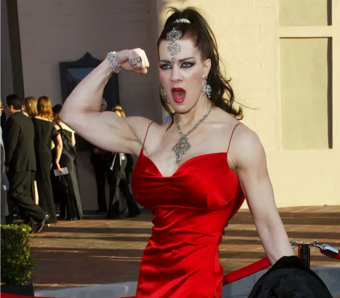 In this Nov. 16, 2003 file photo, Joanie Laurer, former pro wrestler known as Chyna, flexes her bicep as she arrives at the 31st annual American Music Awards, in Los Angeles. Chyna, the WWE star who became one of the best known and most popular female professional wrestlers in history in the late 1990s, has died at age 45. Los Angeles County coroners Lt. Larry Dietz says Chyna, whose real name is Joan Marie Laurer, was found dead in Redondo Beach on Wednesday, April 20, 2016. (AP Photo/Kevork Djansezian)