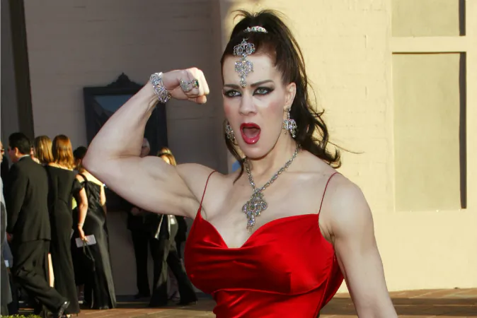 In this Nov. 16, 2003 file photo, Joanie Laurer, former pro wrestler known as Chyna, flexes her bicep as she arrives at the 31st annual American Music Awards, in Los Angeles. (AP Photo/Kevork Djansezian, File)