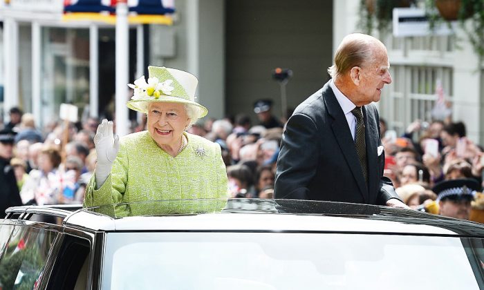 Britain's Queen Elizabeth II (L) and Prince Philip, Duke of Edinburgh wave to wellwishers during a 'walkabout' on her 90th birthday in Windsor, west of London, on April 21, 2016. (JOHN STILLWELL/AFP/Getty Images)