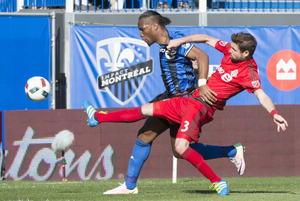 Toronto FC defender Drew Moor stretches to knock the ball away from Montreal Impact forward Didier Drogba at Stade Saputo in Montreal on April 23, 2016. (The Canadian Press/Paul Chiasson)