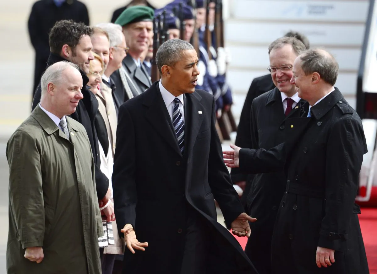 President Barack Obama (C) talks to John B. Emerson (R), U.S. ambassador to Germany, and Stephan Weil (2R), governor of German state of Lower Saxony, upon his arrival at the airport in Hannover, northern Germany, on April 24, 2016. (AP Photo/Jens Meyer)