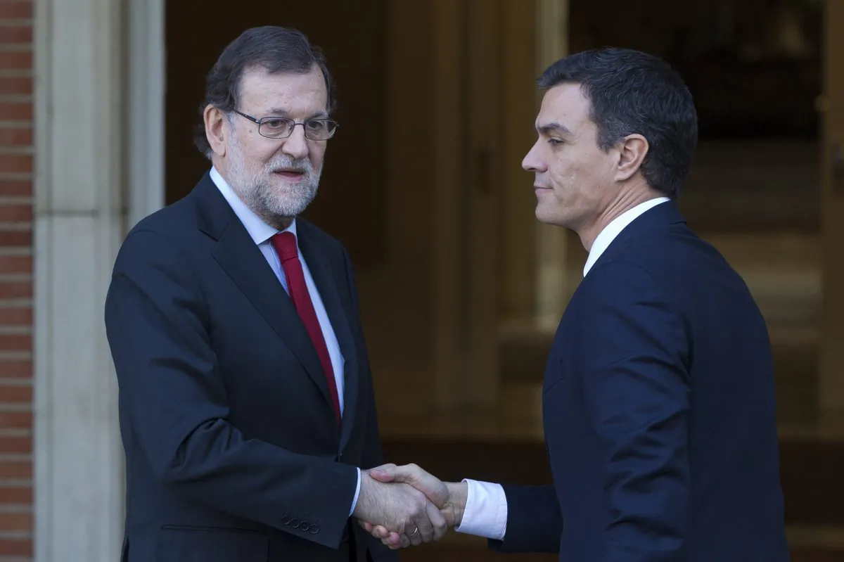 Spain's acting Prime Minister Mariano Rajoy (L) shakes hands with main Socialist opposition leader Pedro Sanchez before a meeting at the Moncloa Palace in Madrid, Spain, on Dec. 23, 2016. (AP Photo/Paul White)