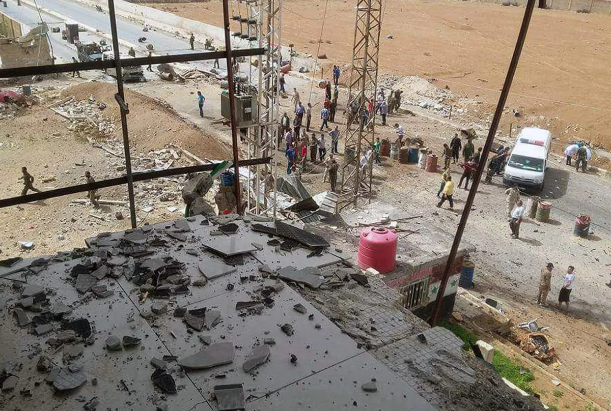 This image released by the Syrian official news agency SANA, shows Syrian citizens gathering at the scene where a suicide bomber detonated his explosives-packed vehicle at a military checkpoint at the entrance to the Sayyida Zeinab suburb, Damascus, Monday, April 25, 2016. A bomb blast in a Damascus suburb that is home to one of the holiest Shiite shrines in Syria killed eight people on Monday, according to a pro-government TV station and an activist-run monitoring group. (SANA via AP)