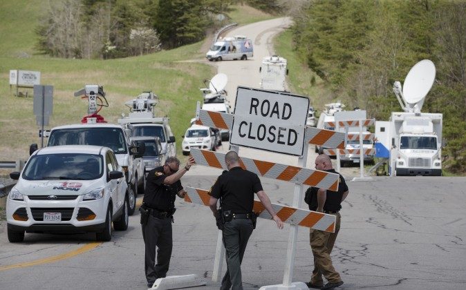 Authorities set up road blocks at the intersection of Union Hill Road and Route 32 at the perimeter of a crime scene, Friday, April 22, 2016, in Pike County, Ohio. (AP Photo/John Minchillo)