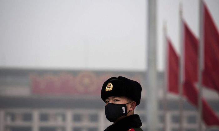 A Chinese paramilitary police officer wears a mask to protect against pollution in Tiananmen Square on Dec. 9, 2015 in Beijing, China. (Kevin Frayer/Getty Images)
