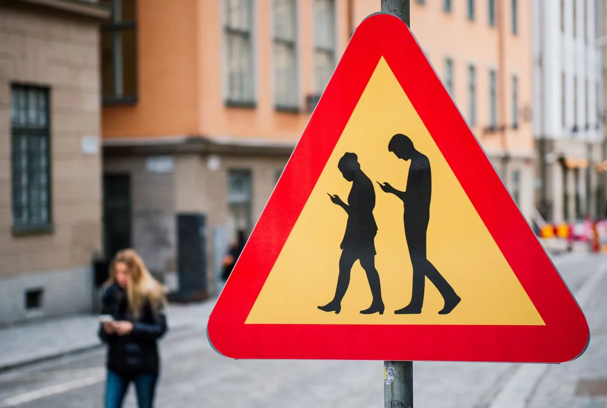 A road sign Warning Against pedestrians focusing on their smartphones, near the old town in Stockholm on Feb. 2, 2016. (Jonathan Nackstrand/AFP/Getty Images)