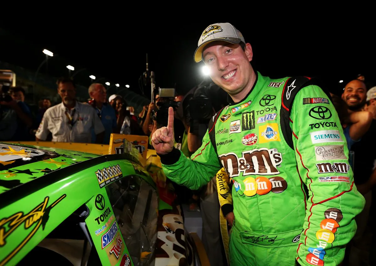 Kyle Busch, driver of the #18 M&M's Crispy Toyota, affixes the winners decal to his car in Victory Lane after winning the series championship and the NASCAR Sprint Cup Series Ford EcoBoost 400 at Homestead-Miami Speedway on November 22, 2015 in Homestead, Florida. (Chris Graythen/Getty Images)