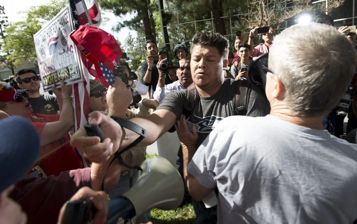 A man (C) sprays Republican presidential candidate Donald Trump supporters with pepper spray during a rally in front of the Anaheim City Hall, in Anaheim, Calif., on April 26, 2016. (Leonard Ortiz/The Orange CountyRegister via AP)