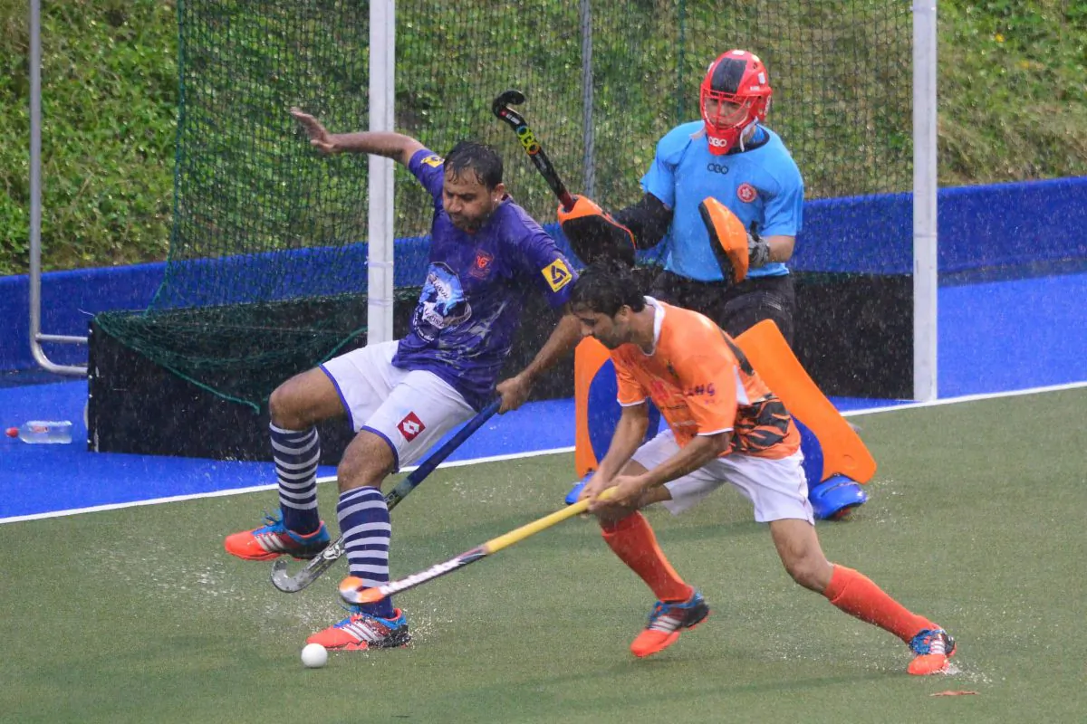 Slip sliding away: A KNS-A player shows his balancing skills as he tries to avoid getting hit on the wet and slippery surface at King's Park in the Holland Cup quarter finals on Sunday April 24, 2016. (Eddie So)