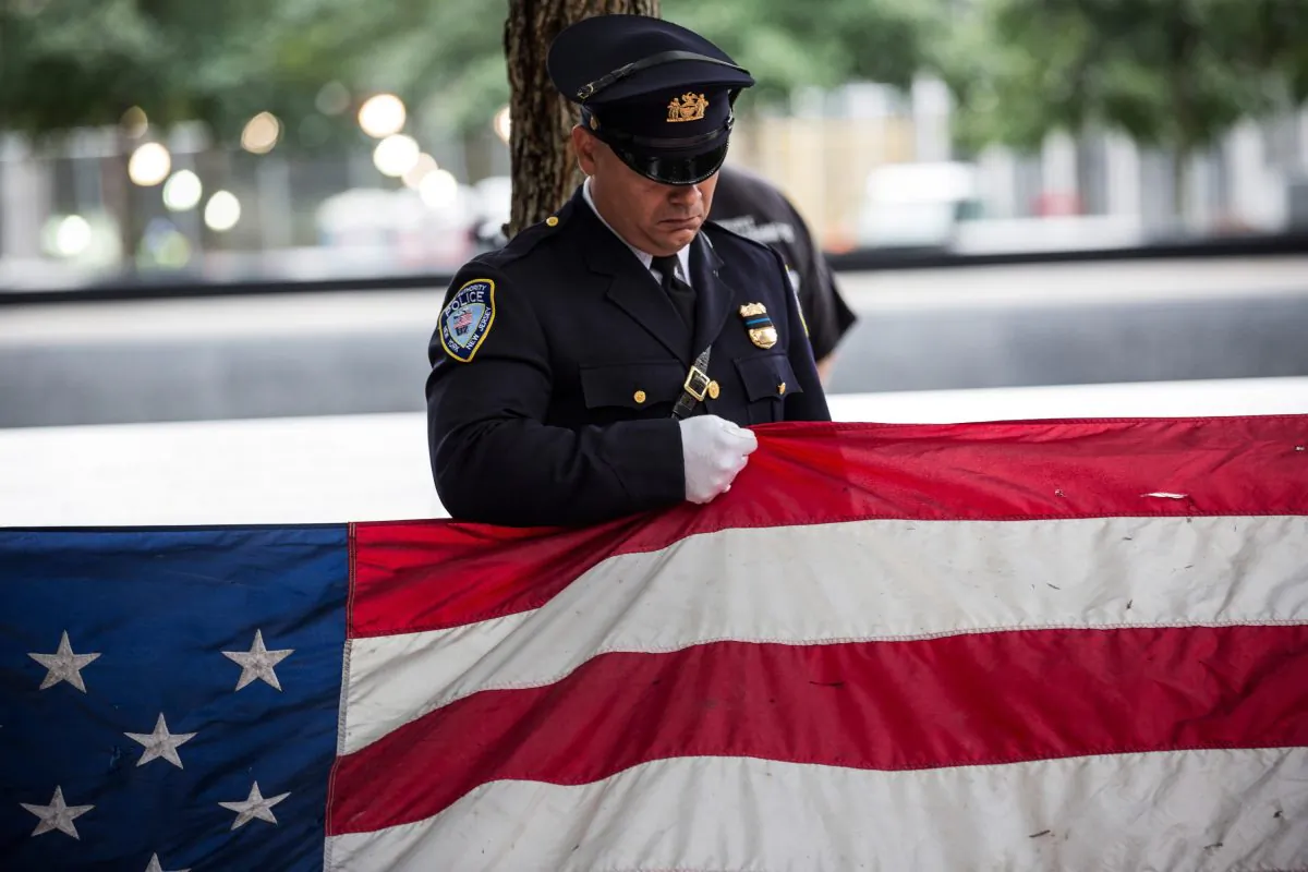 A Port Authority Police officer prepares to present an American flag that survived the terrorist attacks of Sept. 11, 2001, during an anniversary ceremony in New York City on Sept. 11, 2015. (Andrew Burton/Getty Images)