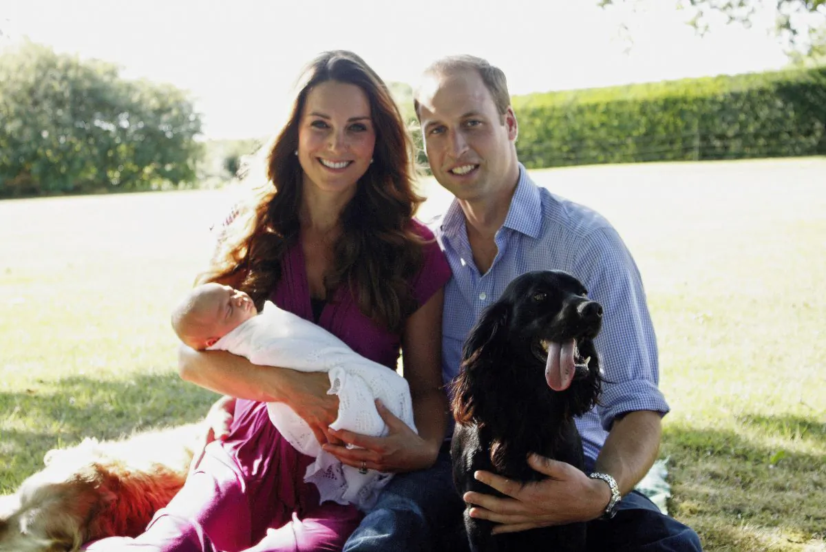 Catherine, Duchess of Cambridge and Prince William, Duke of Cambridge pose for a photograph with their son, Prince George Alexander Louis of Cambridge, surrounded by Lupo, the couple's cocker spaniel, and Tilly the retriever (a Middleton family pet) in the garden of the Middleton family home in August 2013 in Bucklebury, Berkshire.  (Michael Middleton - WPA Pool/Getty Images)