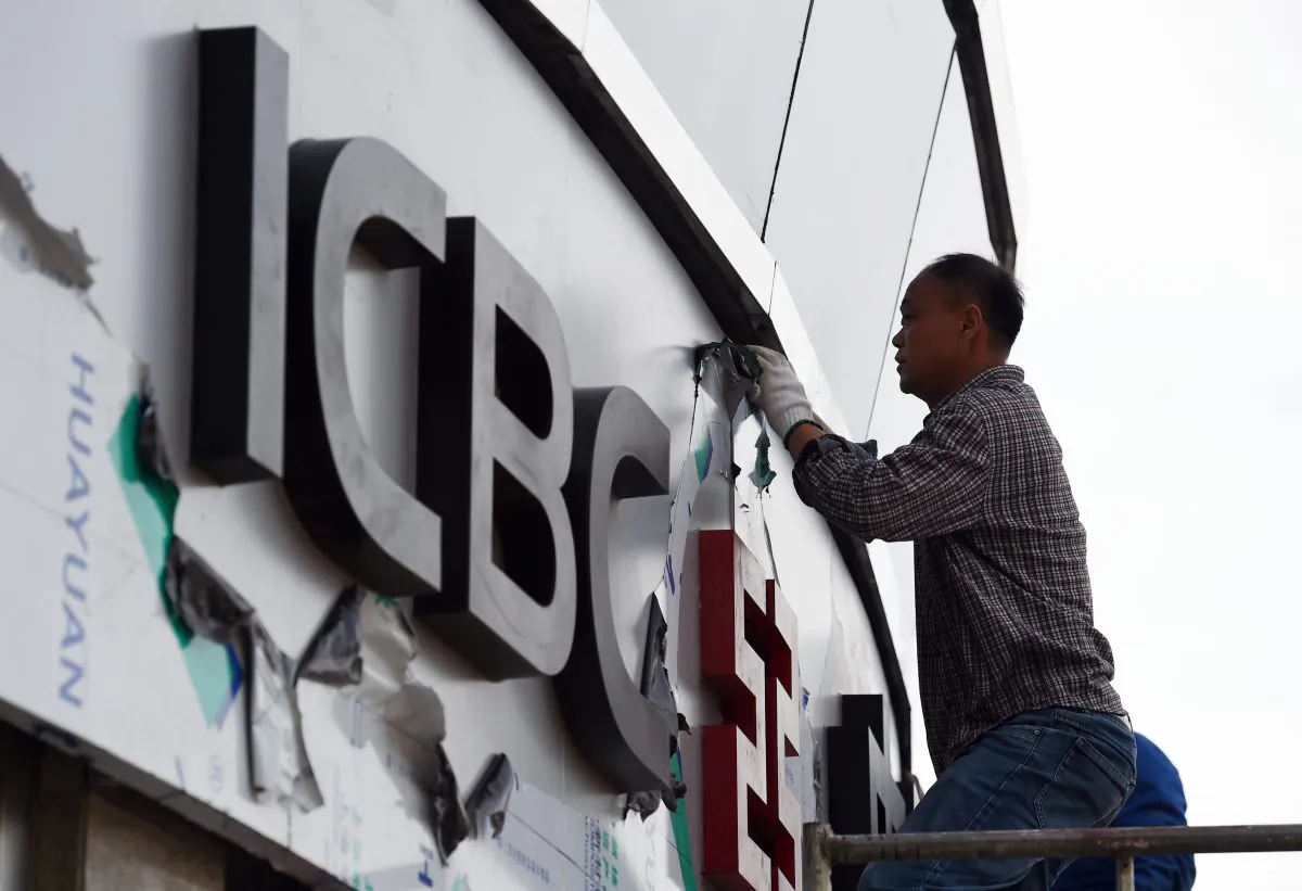 A worker installs sign outside a branch of the Industrial and Commercial Bank of China (ICBC) in Beijing, China, on May 5, 2015. (Greg Baker/AFP/Getty Images)